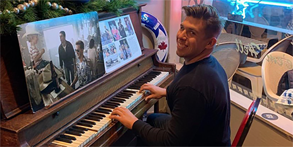 Brandon sonriendo y tocando el piano