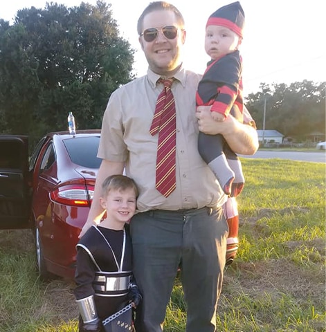 Ryan posando afuera con sus hijos disfrazados