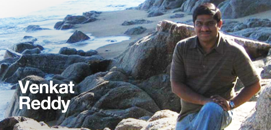 Paciente masculino, Chama, sentado sobre rocas en la playa